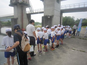 頭首工で説明を受ける児童たちの写真